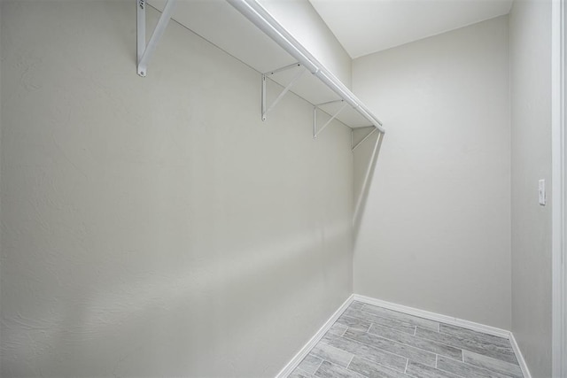 walk in closet featuring wood finish floors