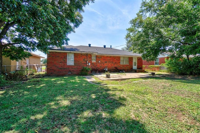 rear view of house with fence, a yard, crawl space, a patio area, and brick siding