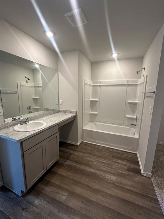 43067 Wagon Trl, Shawnee, OK 74804 - bathroom featuring vanity, washtub / shower combination, and wood finished floors
