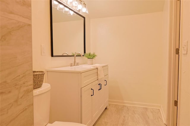 bathroom featuring marble finish floor, vanity, toilet, and baseboards