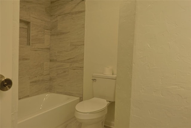 bathroom featuring a textured wall and toilet