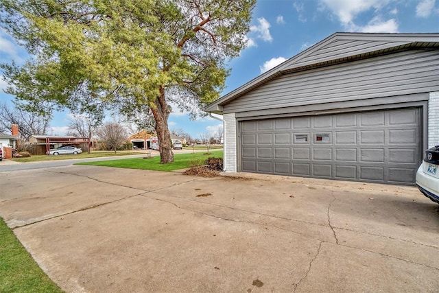 garage featuring concrete driveway