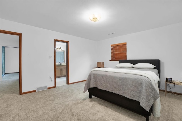 bedroom featuring baseboards, visible vents, a sink, and light colored carpet