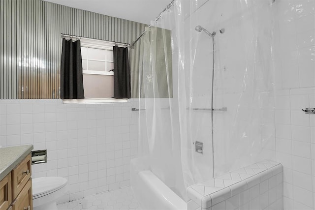 bathroom featuring toilet, vanity, tile walls, tile patterned floors, and shower / bath combo with shower curtain