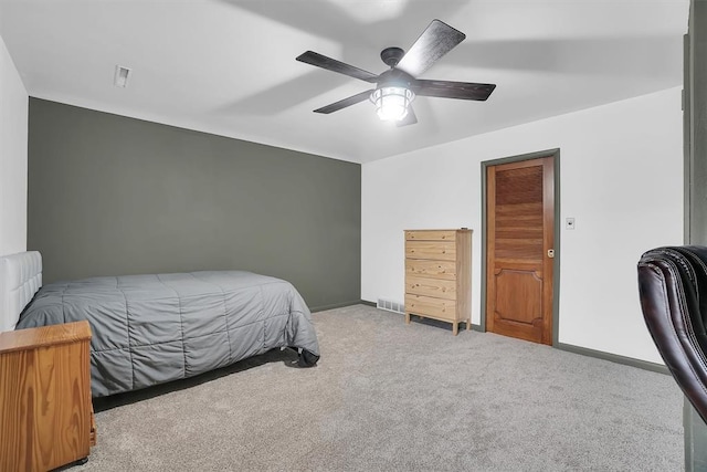 carpeted bedroom with visible vents, baseboards, and a ceiling fan