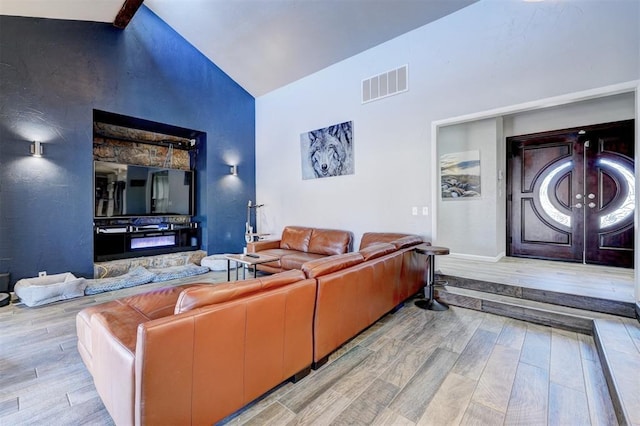 living area featuring high vaulted ceiling, wood finished floors, visible vents, french doors, and beamed ceiling