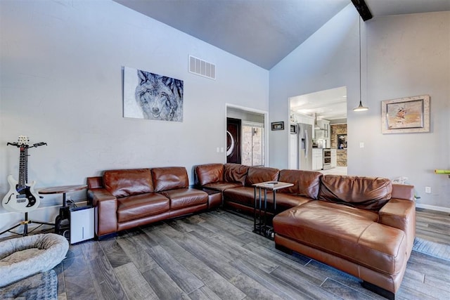 living area featuring baseboards, visible vents, wood finished floors, beamed ceiling, and high vaulted ceiling