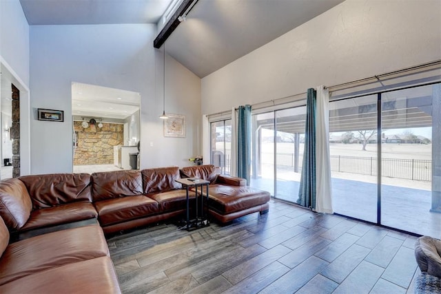 living room with high vaulted ceiling, beam ceiling, rail lighting, and wood finished floors