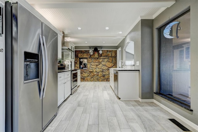 kitchen featuring visible vents, dark countertops, ornamental molding, stainless steel appliances, and white cabinetry