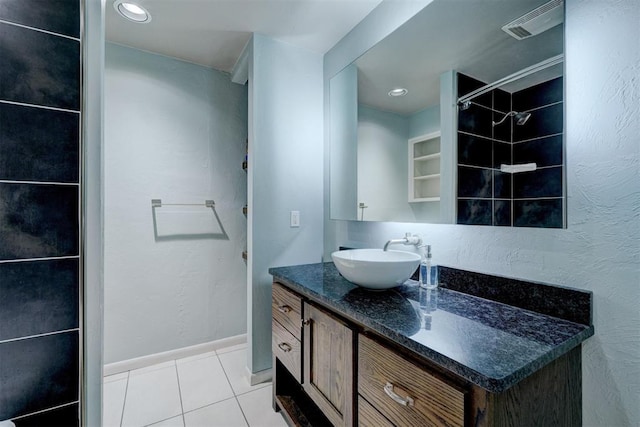 bathroom with baseboards, vanity, visible vents, and tile patterned floors