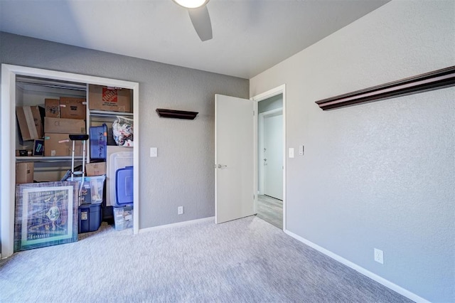 unfurnished bedroom featuring a closet, carpet, a ceiling fan, and baseboards