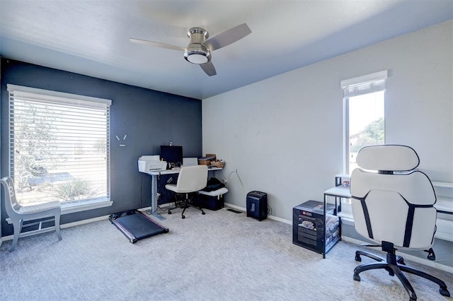 carpeted home office with a ceiling fan, baseboards, and a wealth of natural light