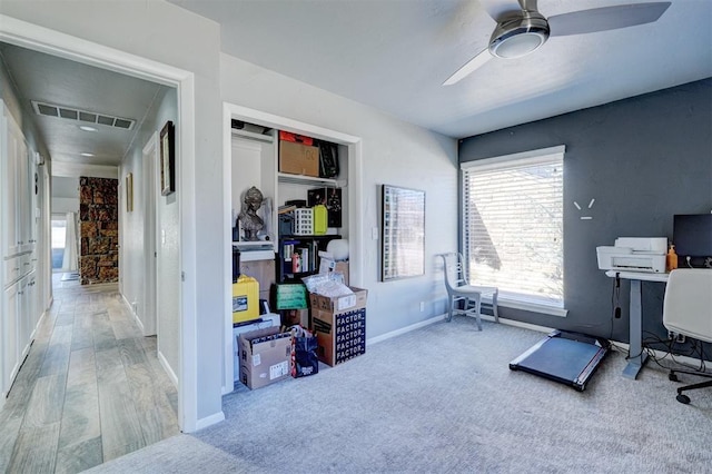 office space with carpet, visible vents, ceiling fan, and baseboards