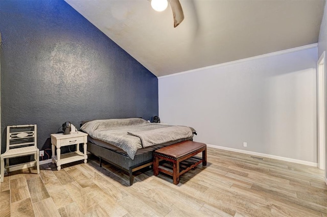 bedroom with baseboards, a ceiling fan, ornamental molding, vaulted ceiling, and light wood-style floors