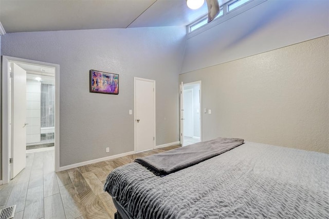 bedroom with visible vents, a textured wall, light wood-style flooring, and baseboards