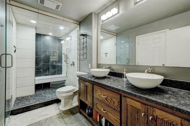 bathroom with visible vents, a sink, and a shower stall