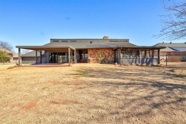 back of property with a yard, a sunroom, a patio area, and fence