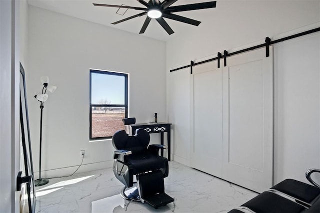 living area featuring a ceiling fan, marble finish floor, and a barn door