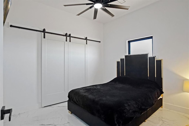 bedroom with marble finish floor, a barn door, baseboards, and ceiling fan