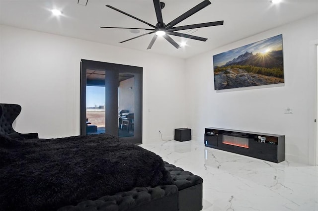 bedroom with ceiling fan, marble finish floor, and a glass covered fireplace