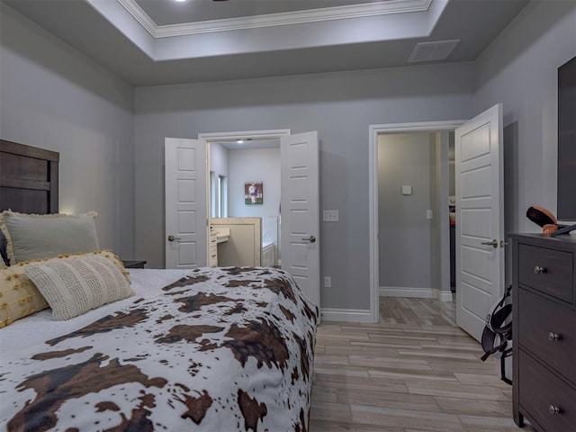 bedroom featuring crown molding, a raised ceiling, visible vents, light wood-style floors, and baseboards