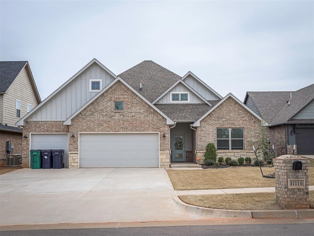 craftsman-style house with a shingled roof, concrete driveway, central air condition unit, board and batten siding, and brick siding