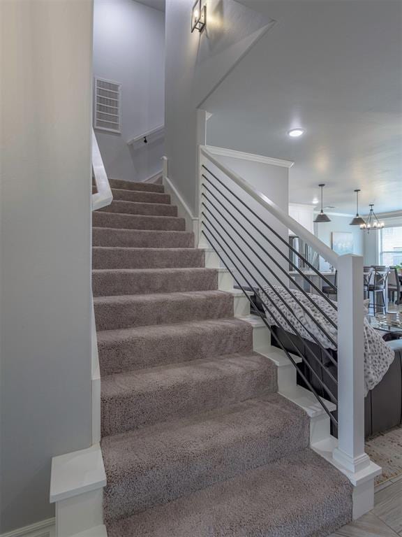 stairway featuring baseboards, recessed lighting, visible vents, and an inviting chandelier