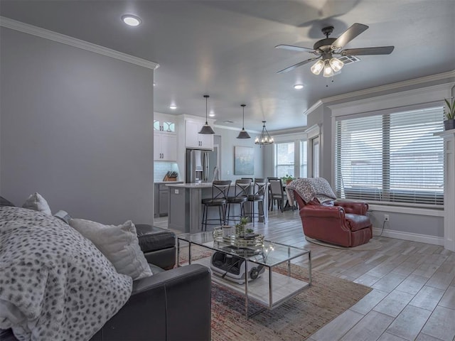 living room featuring wood finish floors, recessed lighting, ornamental molding, baseboards, and ceiling fan with notable chandelier