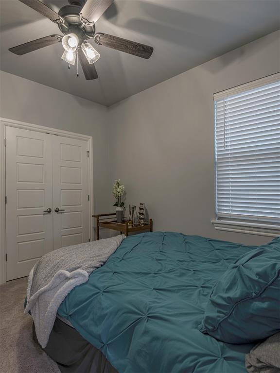 bedroom with a ceiling fan, carpet, and a closet