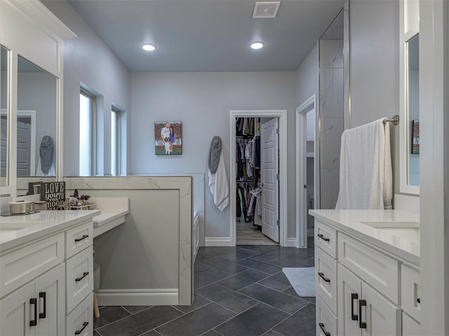 full bath featuring recessed lighting, two vanities, visible vents, baseboards, and a spacious closet