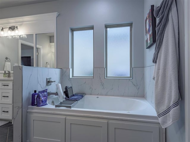 bathroom featuring a garden tub and vanity