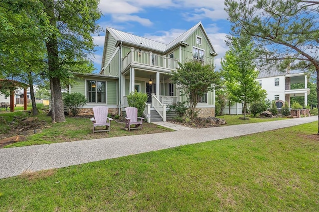 view of front of property featuring a balcony, covered porch, driveway, and a front lawn