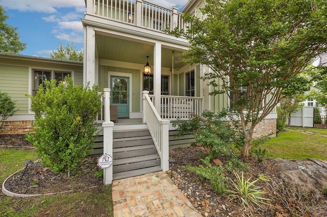 doorway to property featuring covered porch and a balcony