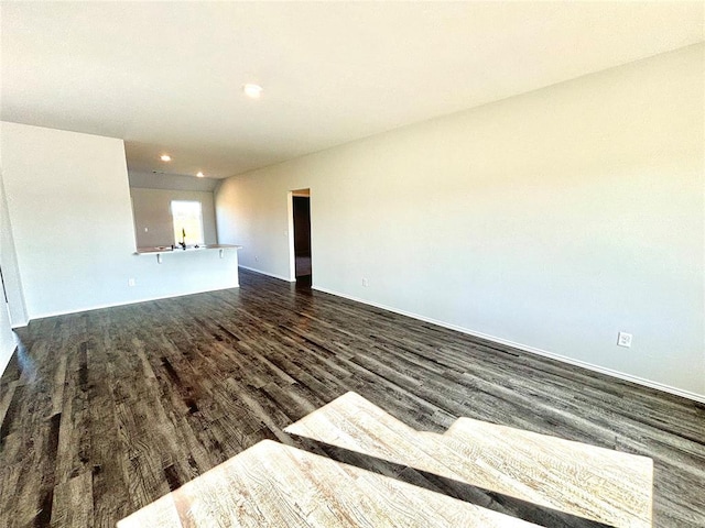 unfurnished room with dark wood-style flooring, a sink, and recessed lighting