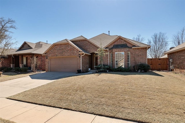 view of front of property with brick siding, concrete driveway, a gate, fence, and a garage