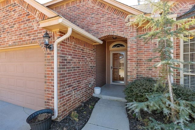 doorway to property featuring brick siding and an attached garage