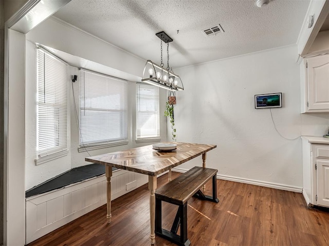 dining room with dark wood finished floors, a textured ceiling, visible vents, and breakfast area