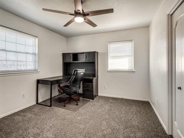 carpeted office featuring baseboards, a textured ceiling, and ceiling fan