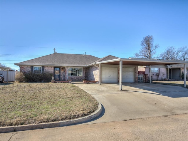 single story home with driveway, a carport, brick siding, a front yard, and a garage