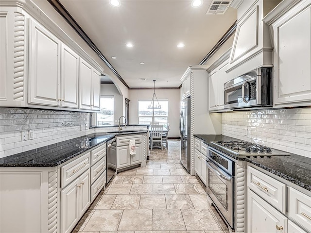 kitchen with stainless steel appliances, a sink, visible vents, white cabinets, and crown molding