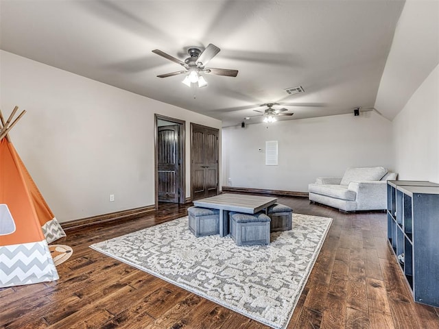 living room featuring baseboards, vaulted ceiling, visible vents, and dark wood finished floors