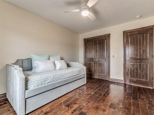 bedroom with hardwood / wood-style floors, a ceiling fan, and baseboards