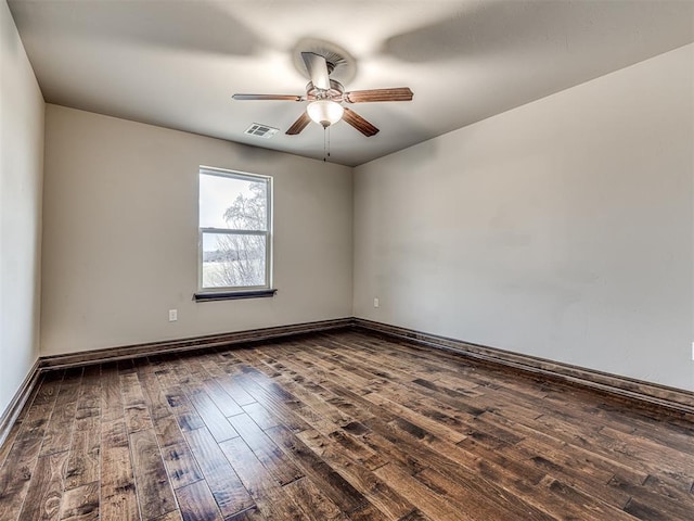 empty room with a ceiling fan, dark wood-style flooring, visible vents, and baseboards