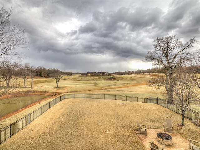 view of yard featuring an outdoor fire pit, fence, and a rural view