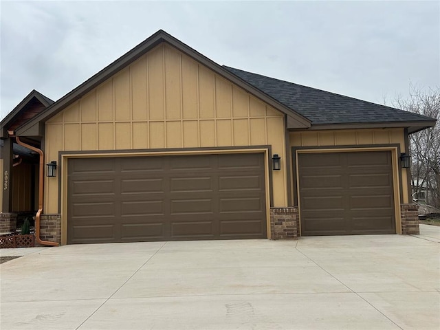 view of front of home featuring board and batten siding, concrete driveway, roof with shingles, and an attached garage