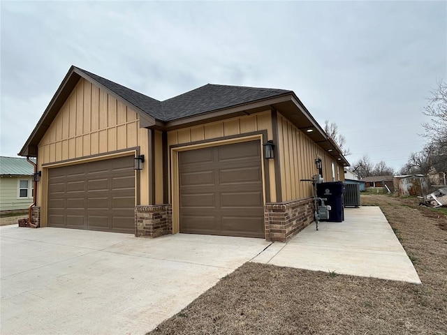 view of front of house with a garage, a shingled roof, board and batten siding, and concrete driveway