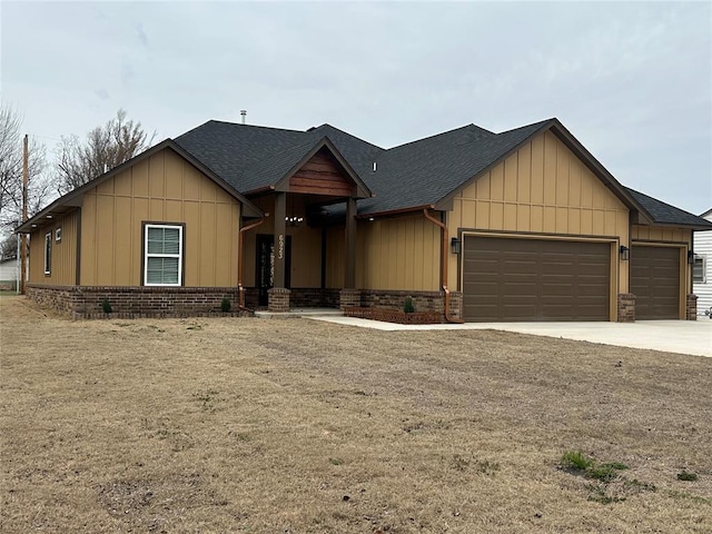 view of front of house featuring board and batten siding, roof with shingles, brick siding, and a garage