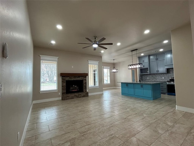 unfurnished living room featuring recessed lighting, a fireplace, ceiling fan, and a sink