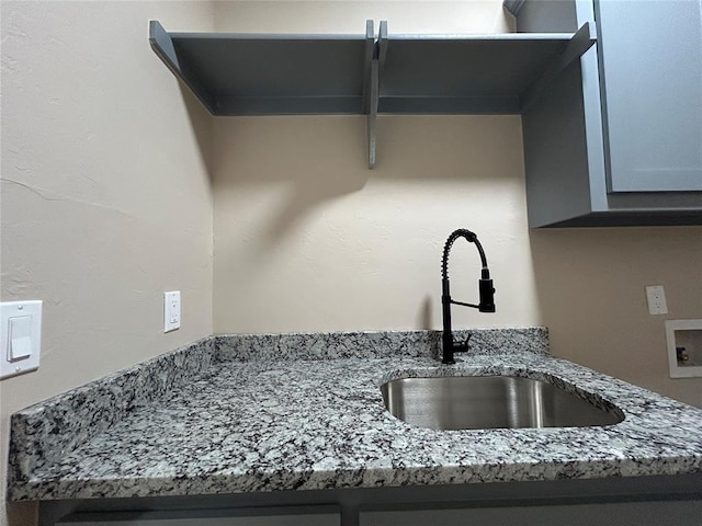 interior details with stone counters and a sink