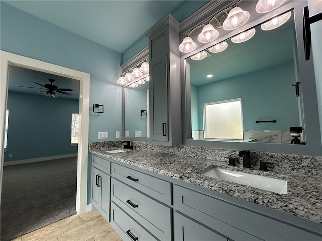 full bathroom featuring a ceiling fan, a sink, baseboards, and double vanity